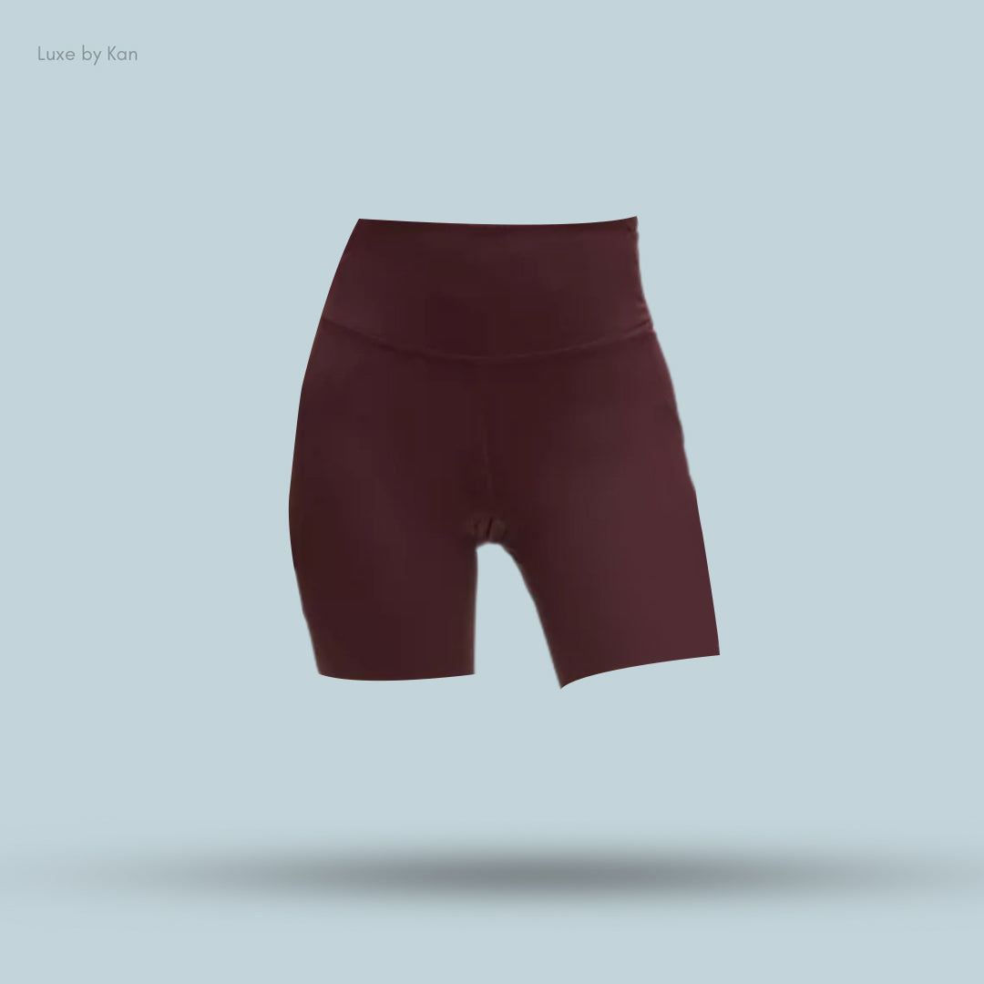 Maroon high-waisted shorts displayed against a light blue background, featuring a smooth, stretchy fabric ideal for activewear.