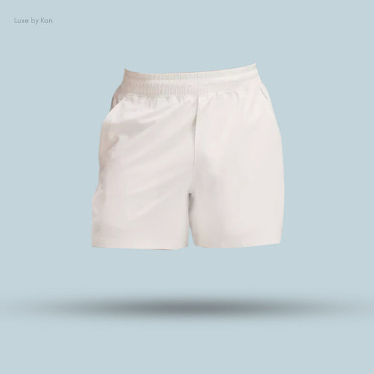 White, lightweight shorts with an elastic waistband, displayed on a light blue background. Brand: Luxe by Kan.