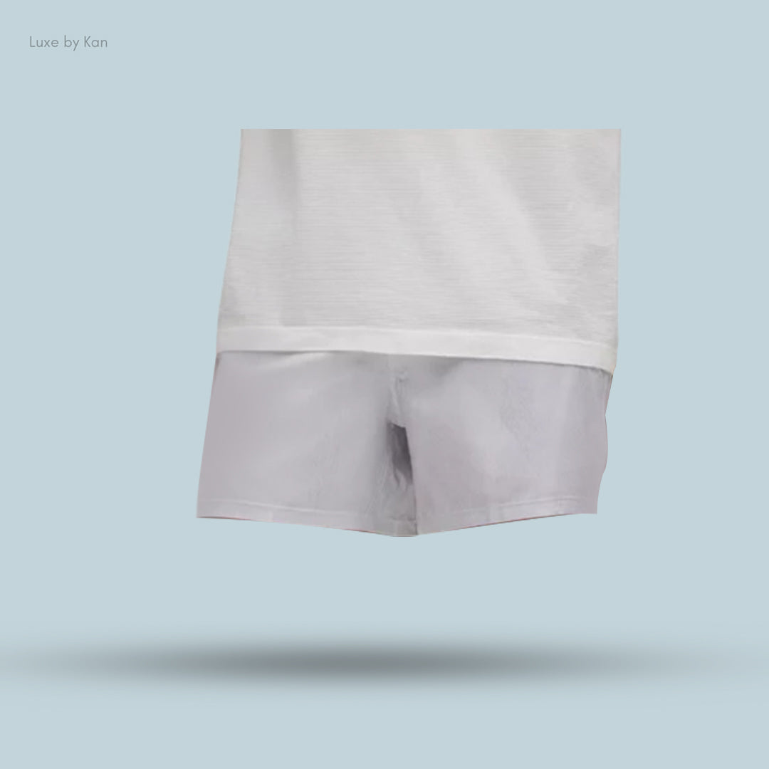 A white shirt paired with light gray Lululemon Pace Breaker Linerless Short 5", showcasing the stylish simplicity of a casual outfit.