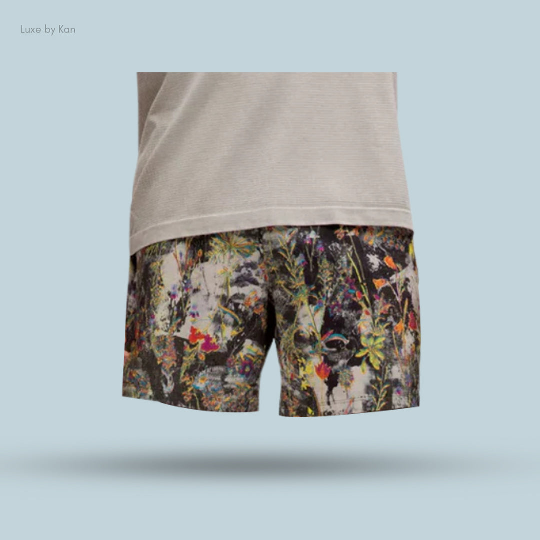 Men's stylish shorts featuring a vibrant floral pattern, paired with a light, casual top against a soft blue background.