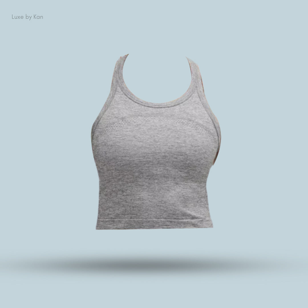 Gray athletic crop top with racerback design, displayed against a light blue background, showcasing its sleek and versatile style.