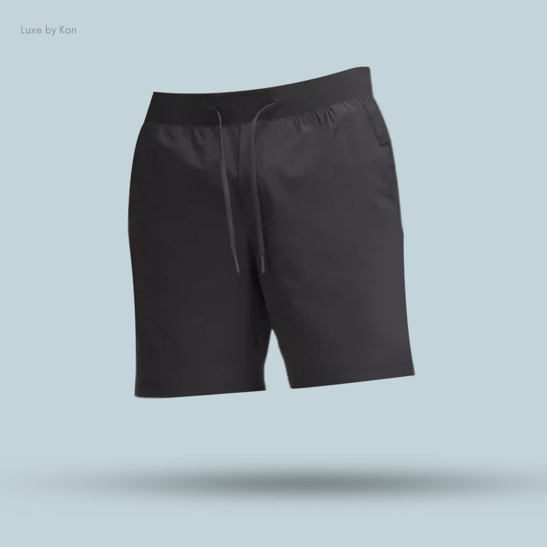 Black athletic shorts with a drawstring, displayed against a light blue background, showcasing a minimalistic design.
