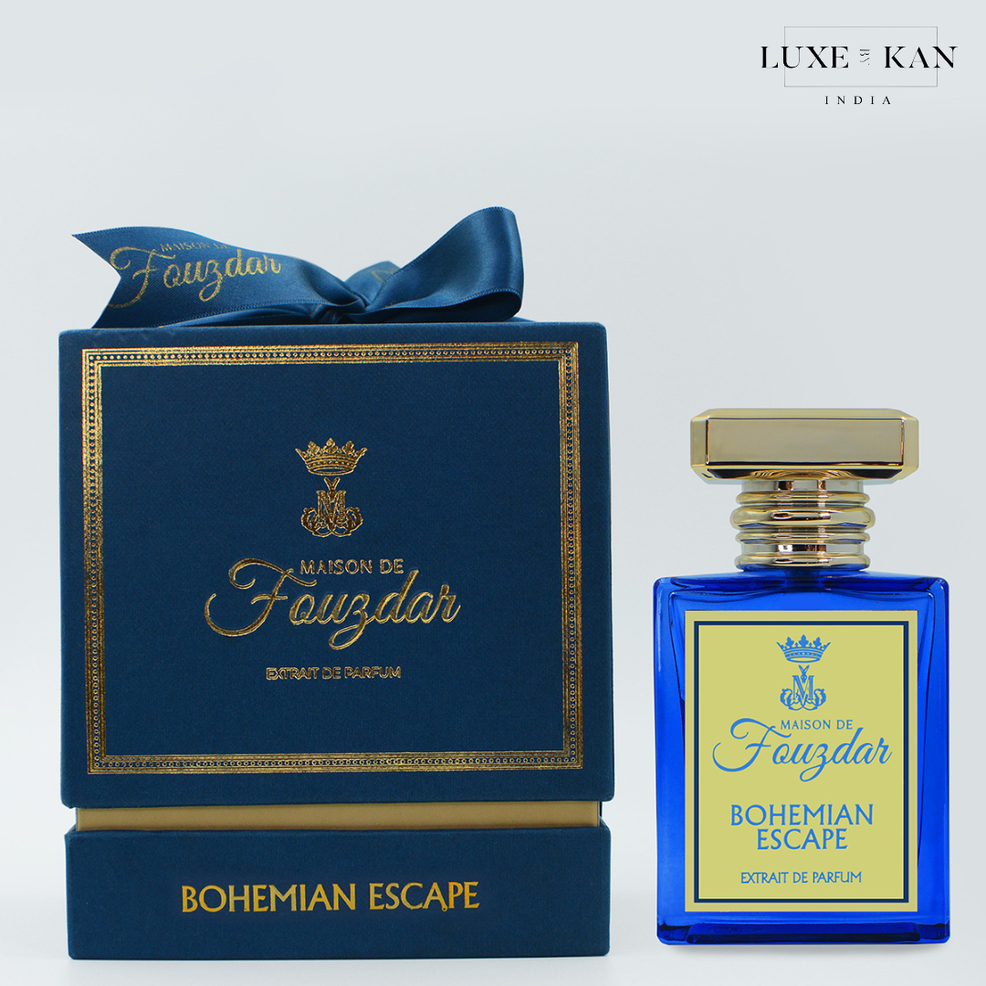 Blue perfume bottle labeled "Bohemian Escape" next to a luxury navy box with gold accents, showcasing Maison de Fouzdar branding.