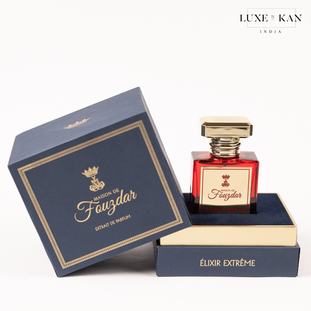 Luxurious perfume bottle in a red glass container, elegantly presented in a navy blue box labeled "Maison de Fauzdar."