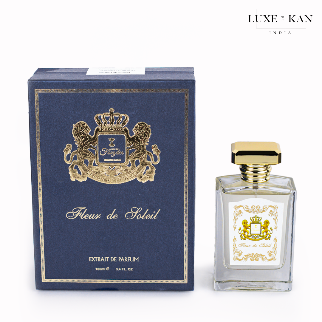Maison de fouzdar fleur de soleil perfume bottle next to a luxurious blue box, adorned with a golden crown and satin ribbon.