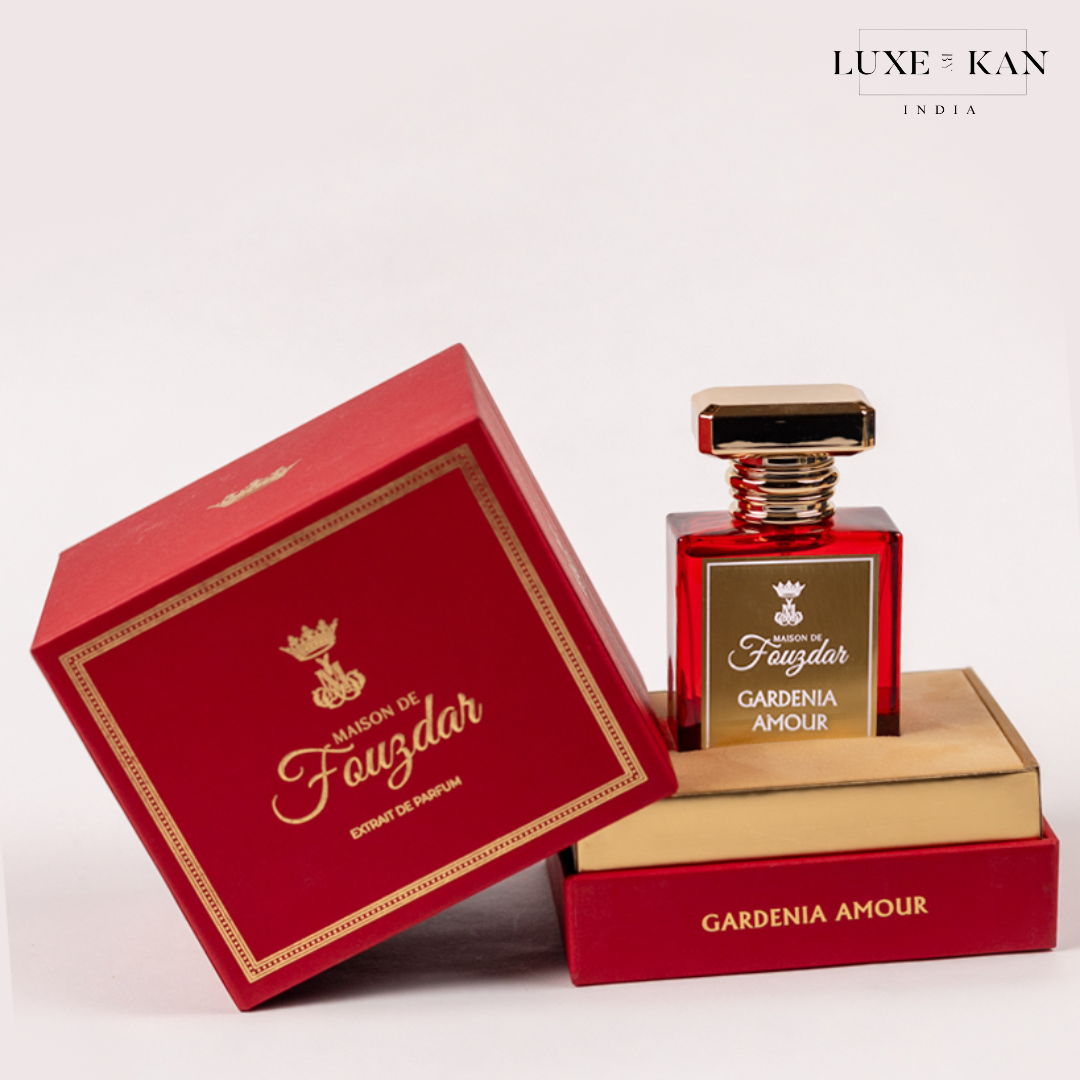 A luxurious red perfume bottle, "Gardenia Amour," displayed in its elegantly designed box with gold accents and logo.