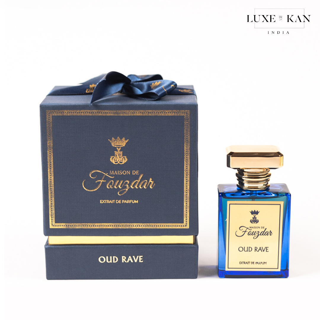 Maison de fouzdar oud rave perfume bottle next to a luxurious blue box, adorned with a golden crown and satin ribbon.