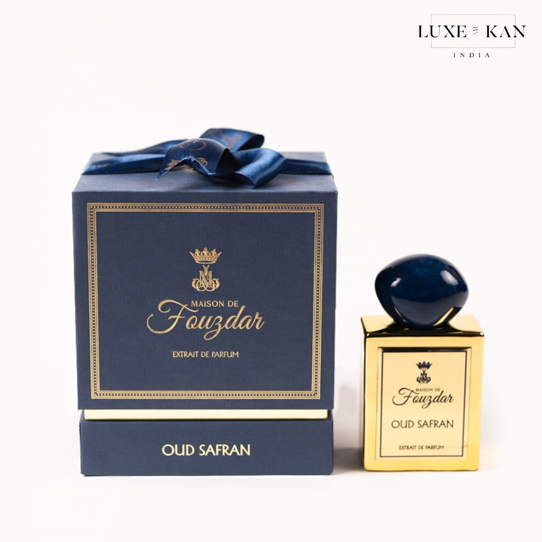 Maison de fouzdar oud safran perfume bottle next to a luxurious blue box.