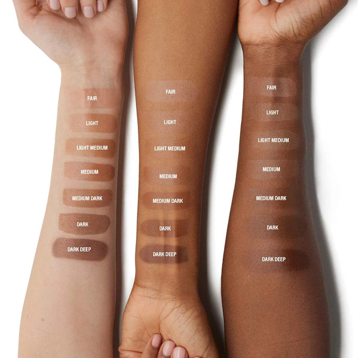 Three arms showcasing a range of skin tone swatches labeled from fair to dark deep, highlighting foundation shades for diverse complexions.