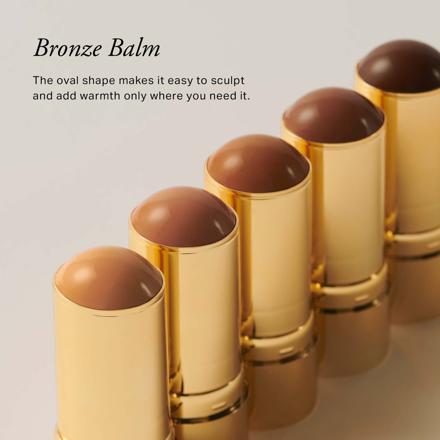 Five gold-cased bronzing balms with oval tops, designed for easy sculpting and adding warmth to the skin.
