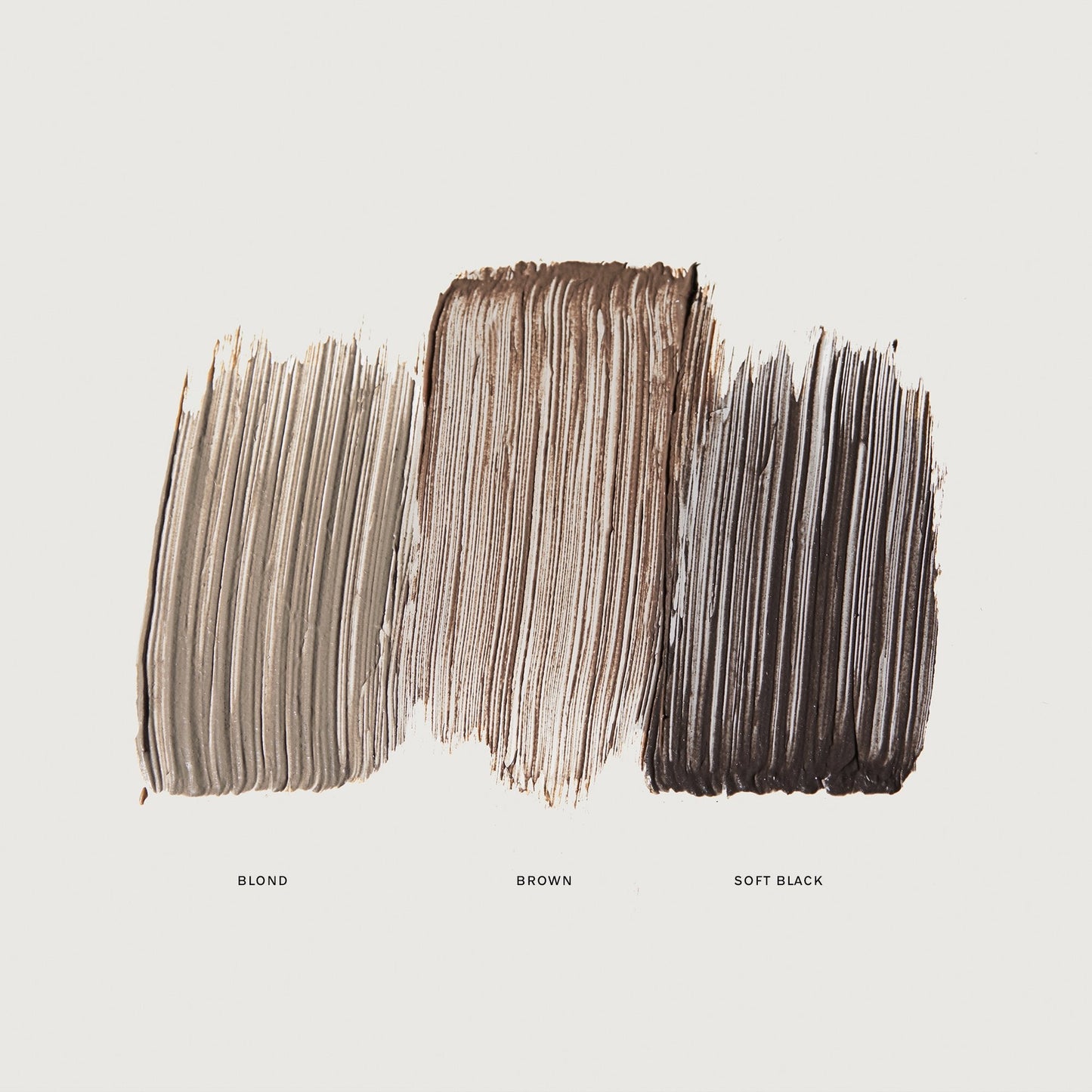 Three horizontal paint swatches labeled "Blond," "Brown," and "Soft Black," showcasing shades of hair color on a white background.