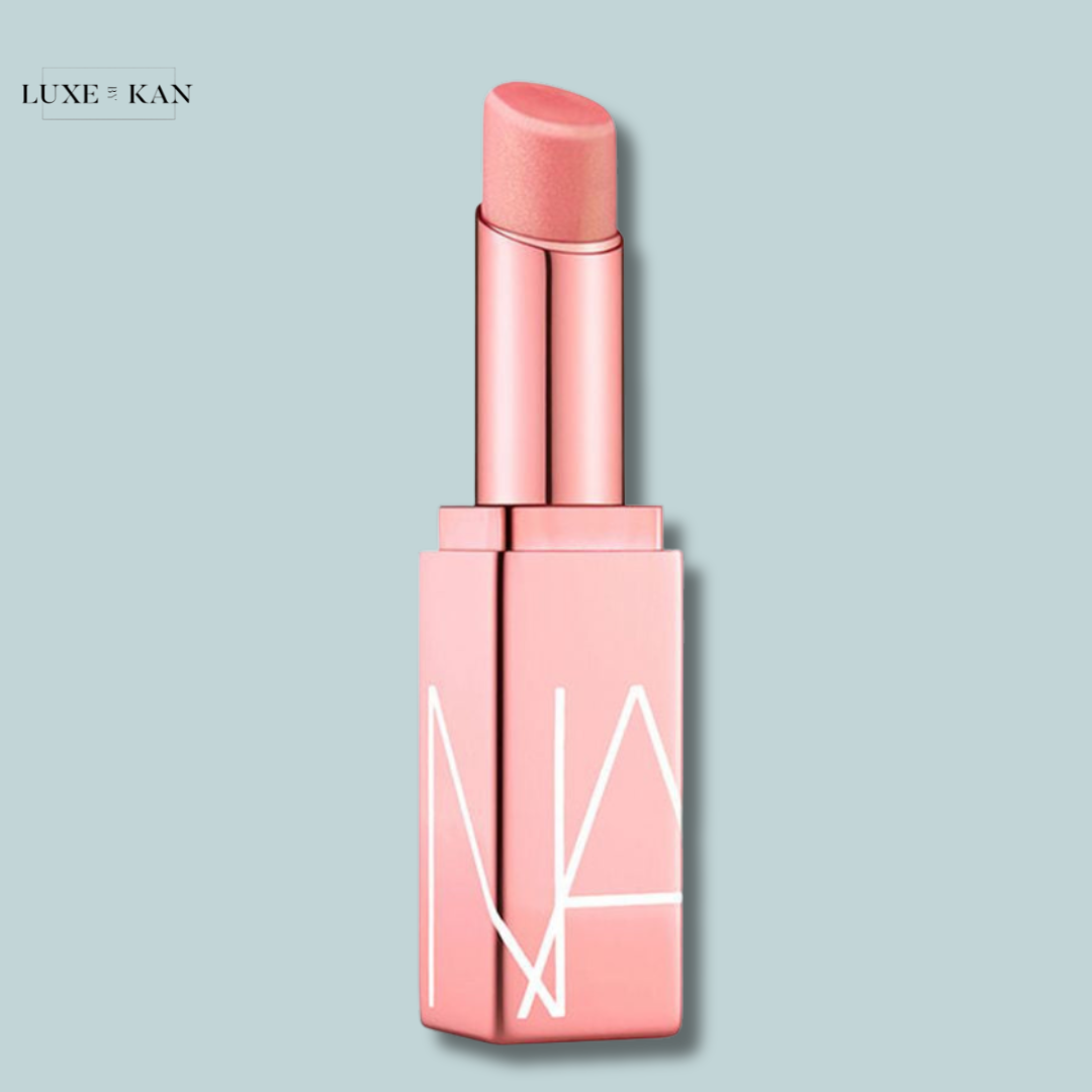 A soft pink nars afterglow lip balm in a sleek, modern tube with a minimalist design.