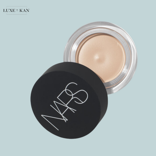 A Nars soft matte complete concealer container with a black lid, partially open to reveal a creamy, light beige product.