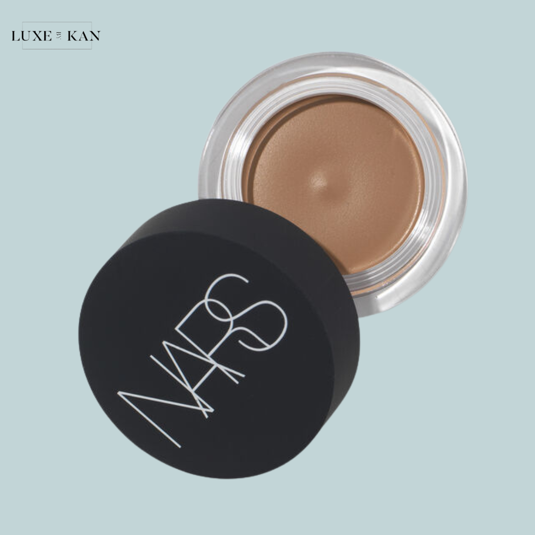 A jar of NARS cream bronzer with a sleek black lid, showcasing a smooth, warm brown product inside.