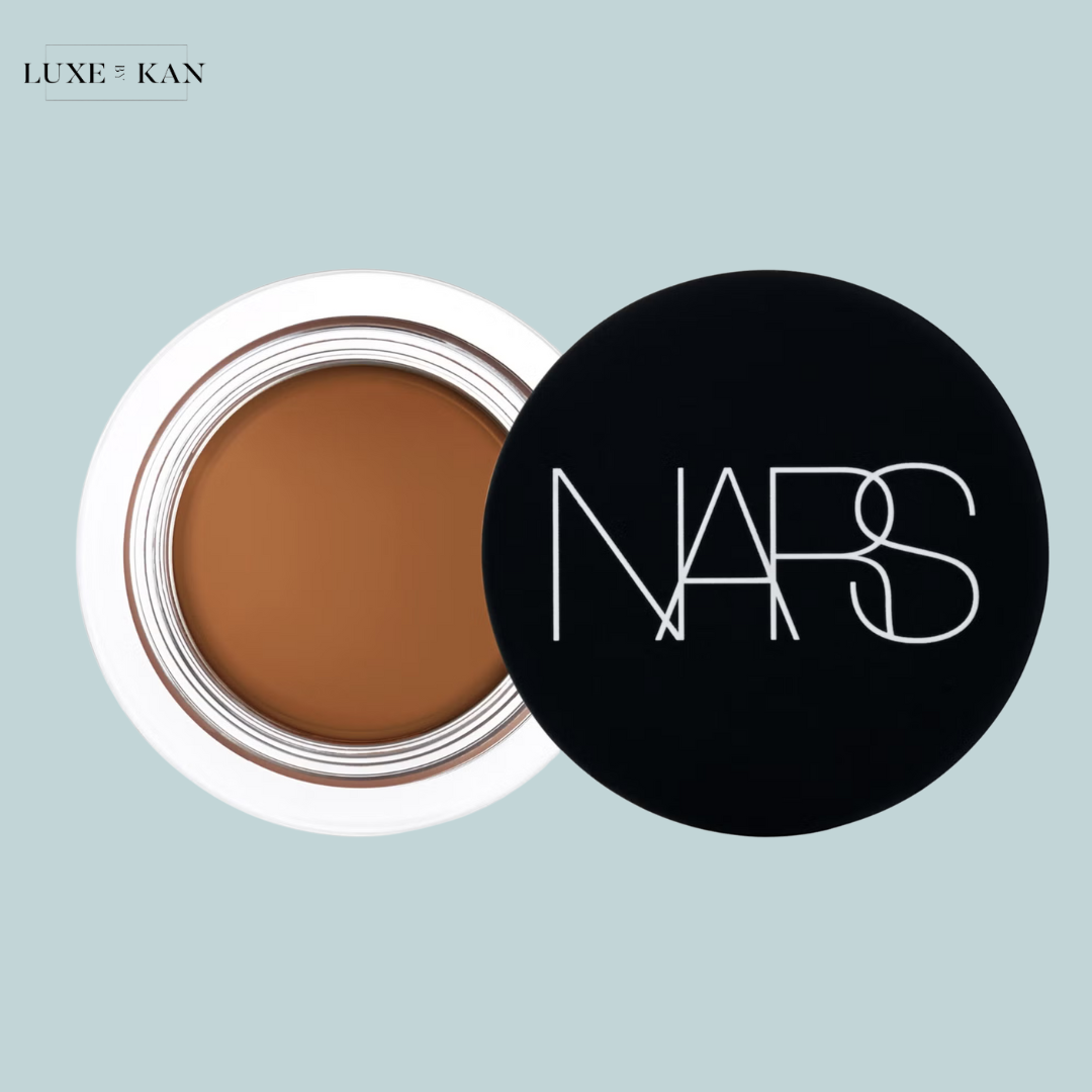 Open NARS concealer pot with a rich brown shade, lying beside its sleek black lid.