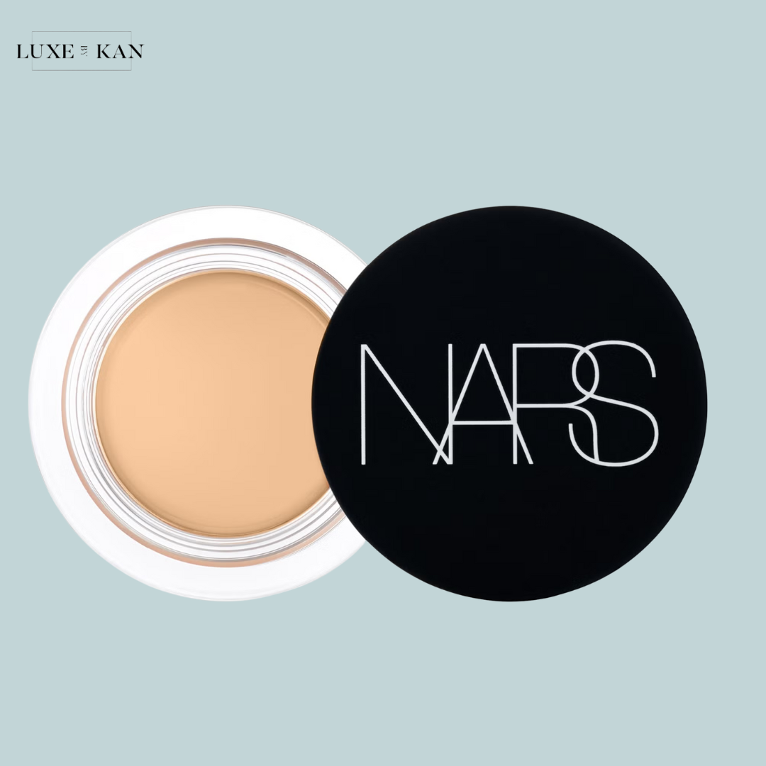 Open jar of NARS foundation with a beige cream inside and a black lid displaying the brand logo.