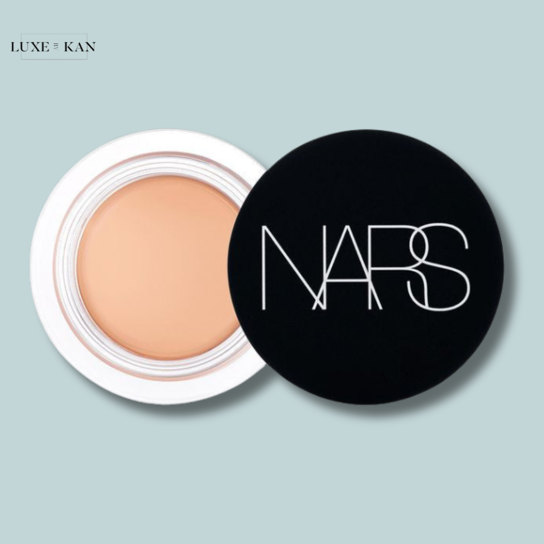 Open NARS cream concealer in a sleek black jar with white lid, showcasing a smooth beige product.