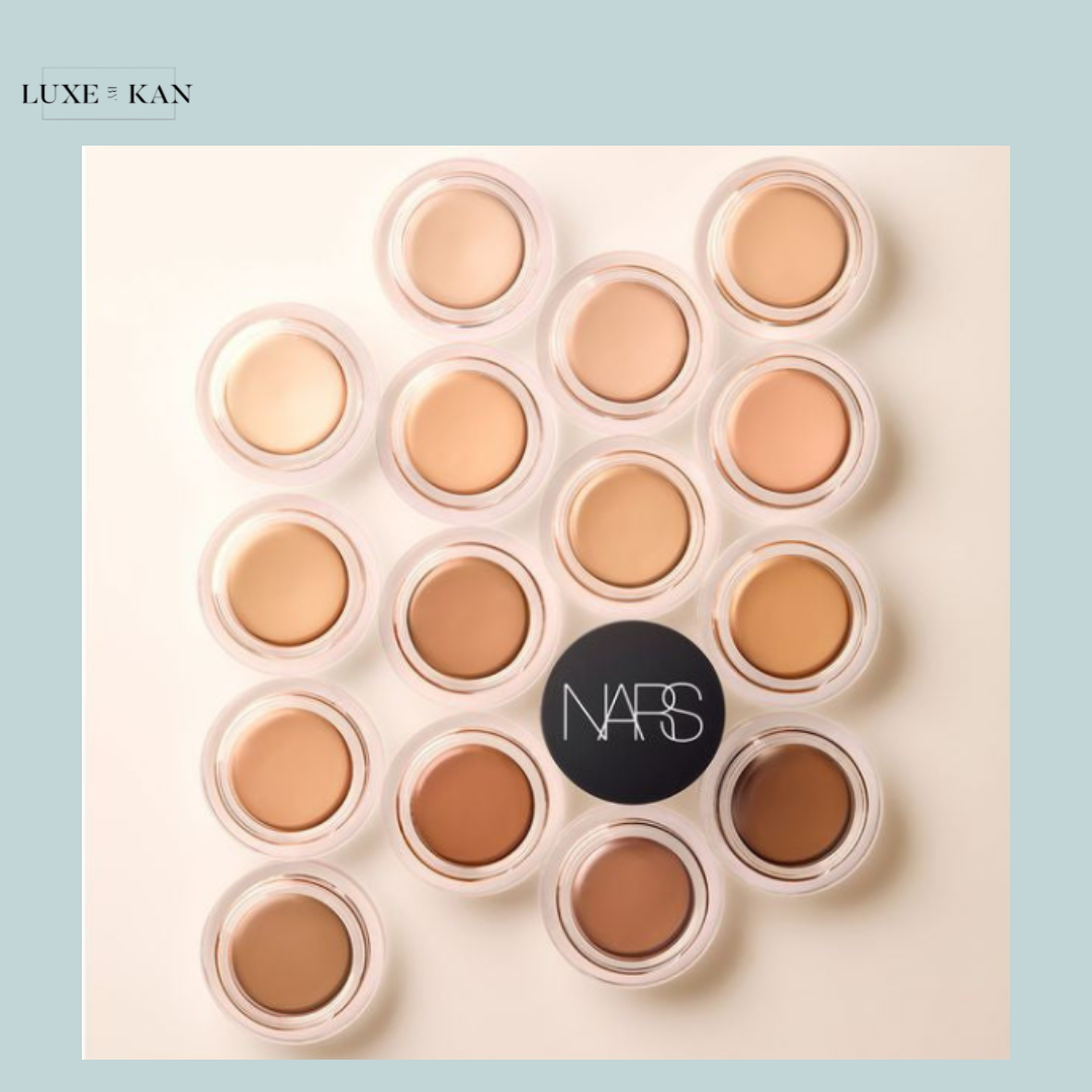 A flat lay of 15 NARS cream foundation pots in various skin tones, with a prominent NARS logo at the center.