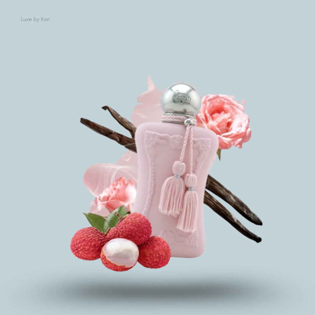 Parfums de marly delina eau de parfum spray, with pale pink bottle and tassel, surrounded by roses, lychee, and vanilla beans.