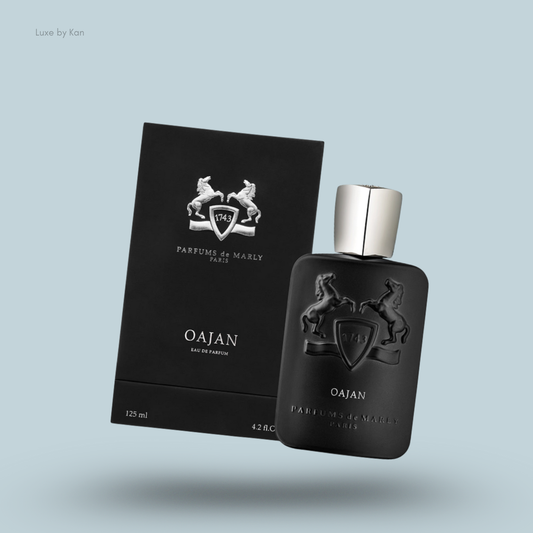 Black bottle of Oajan perfume by Parfums de Marly next to its sleek box.