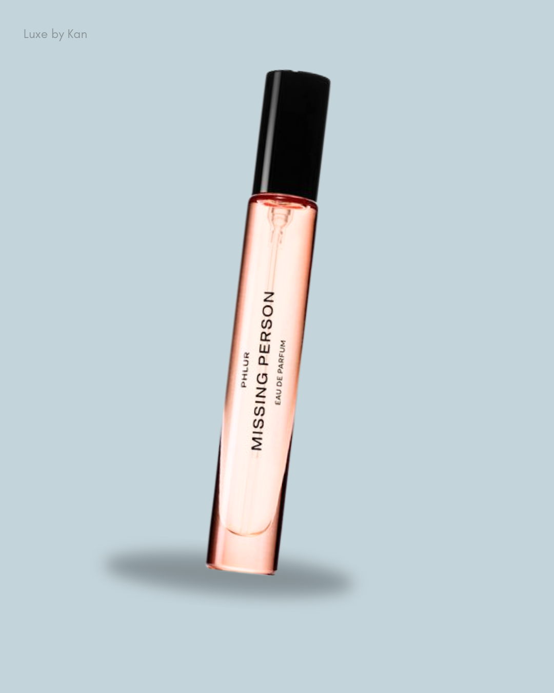 A bottle of Phlur's "Missing Person" eau de parfum, featuring a sleek design with a black cap.