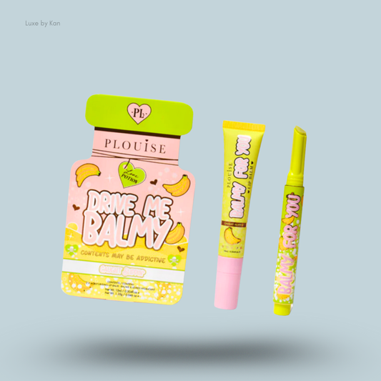 Three colorful beauty products from Plouise: "Drive Me Balmy" lip balm and two lip glosses in vibrant banana-themed packaging.