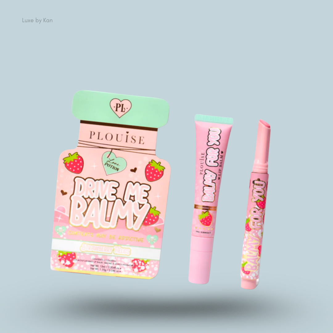 Three Plouise Drive Me Balmy strawberry-scented lip balm products: a boxed compact shaped like a potion bottle with text “Drive Me Balmy”, a tube of lip balm, and a lip balm stick, all on a pale blue background.