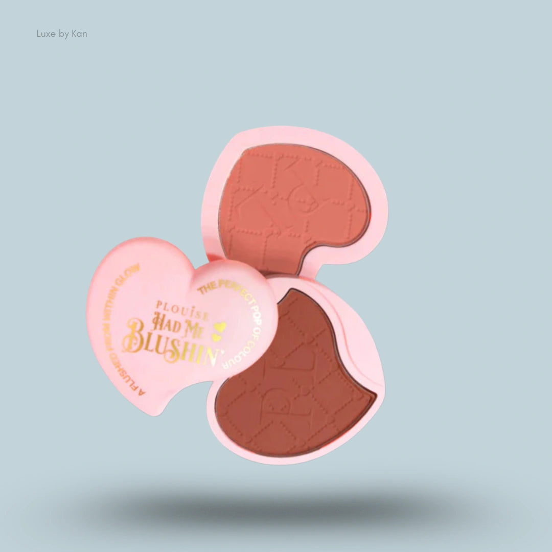 Plouise Had Me Blushin’ powdered blush duo, presented in a heart-shaped, light pink compact with two blush colors visible: one light pink and one brown.