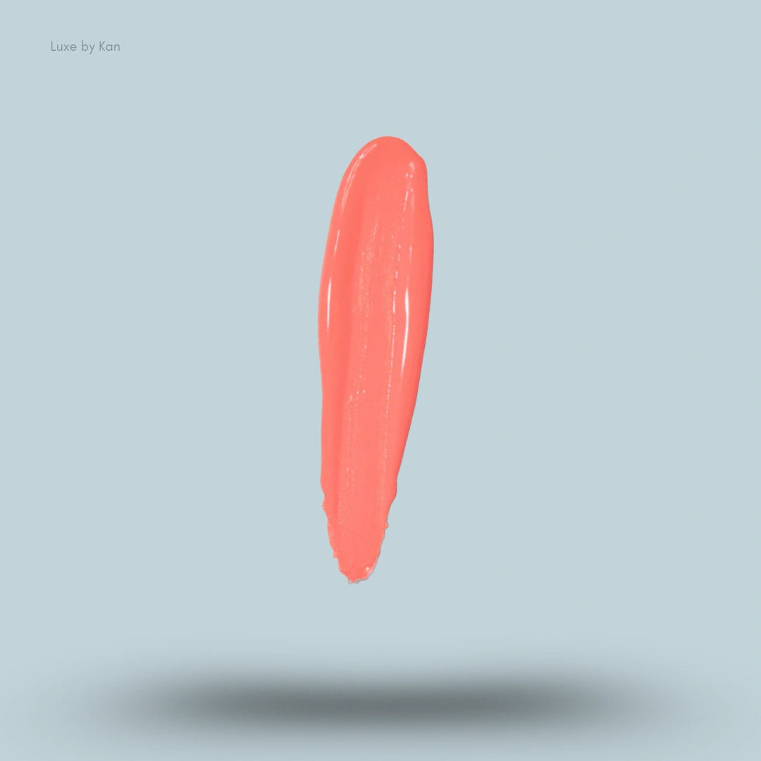 A swatch of Plouise liquid blush in a vertical stroke, with a glossy texture.