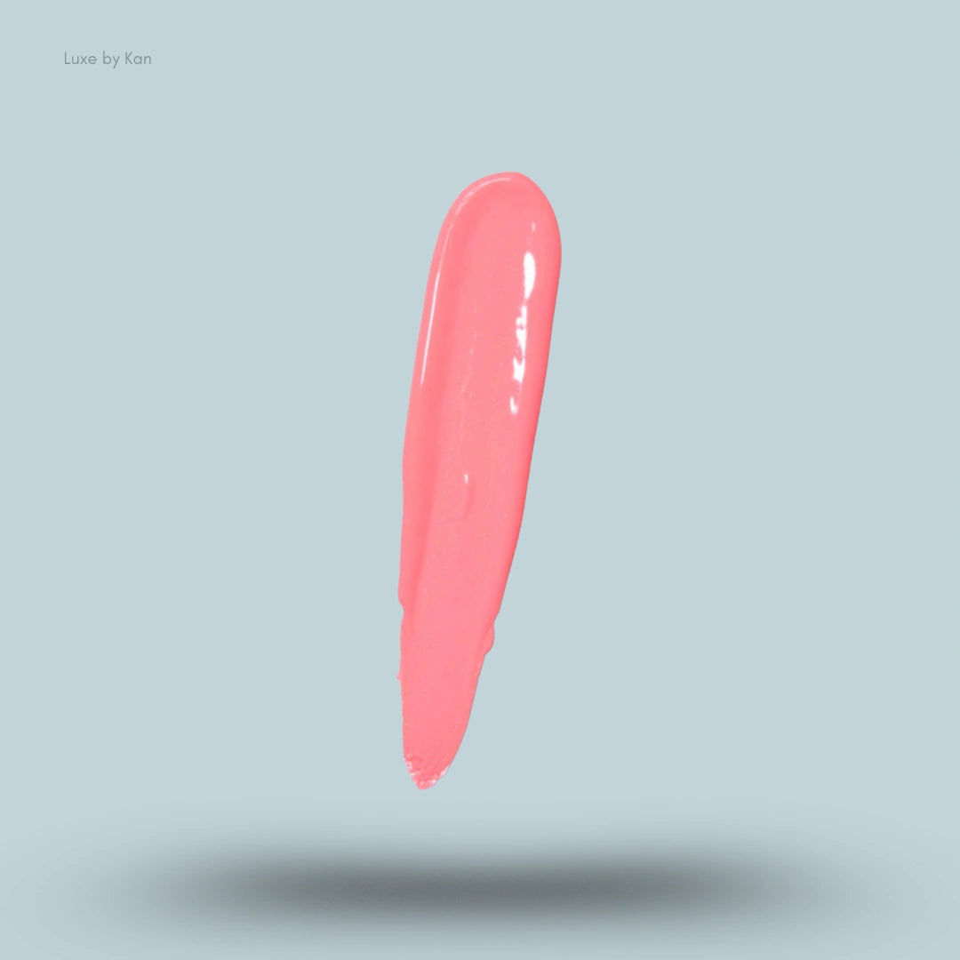 Close-up of a dollop of Plouise “the cheek of it” liquid blush in a coral shade.