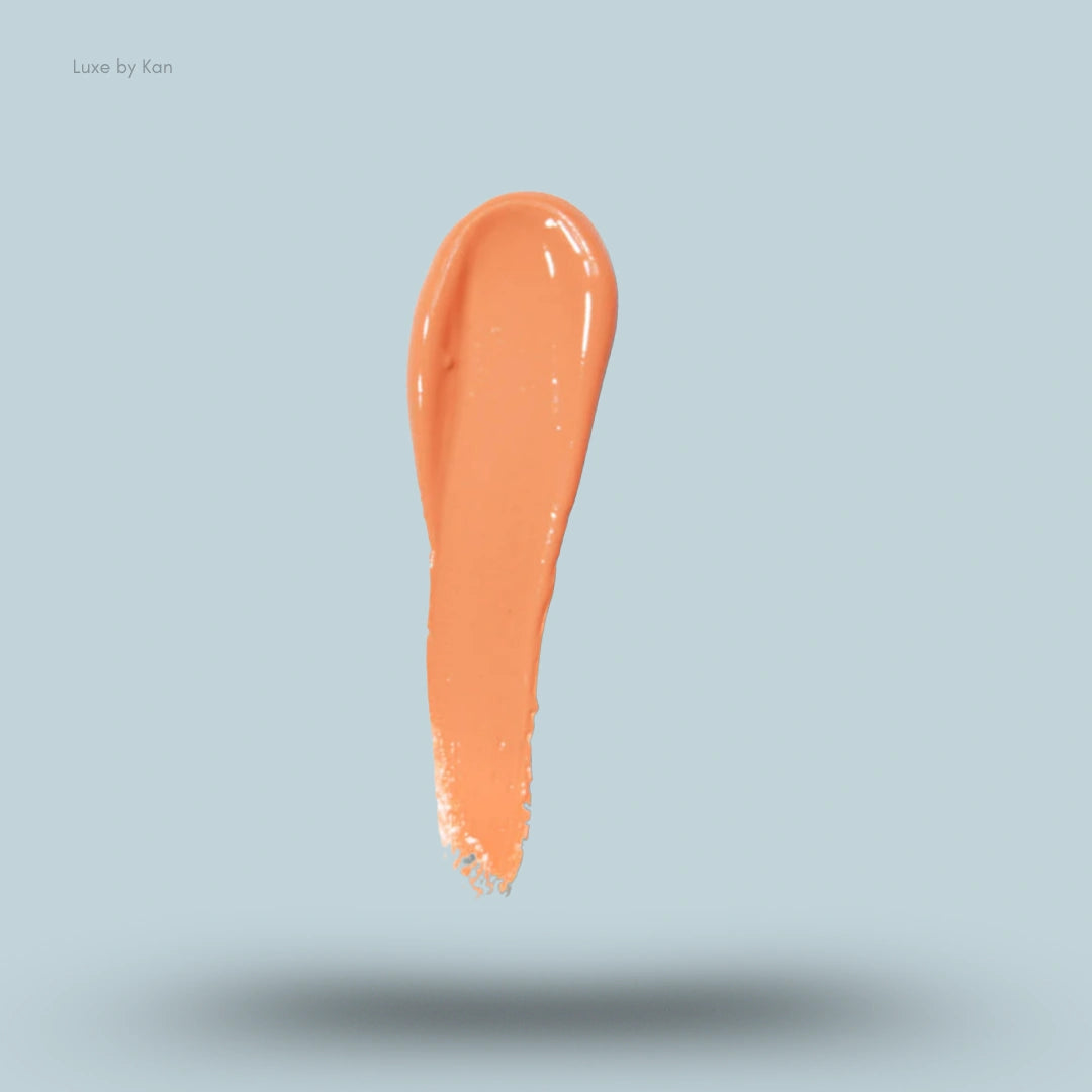 Swath of Plouise liquid blush in an apricot hue, glossy and textured.