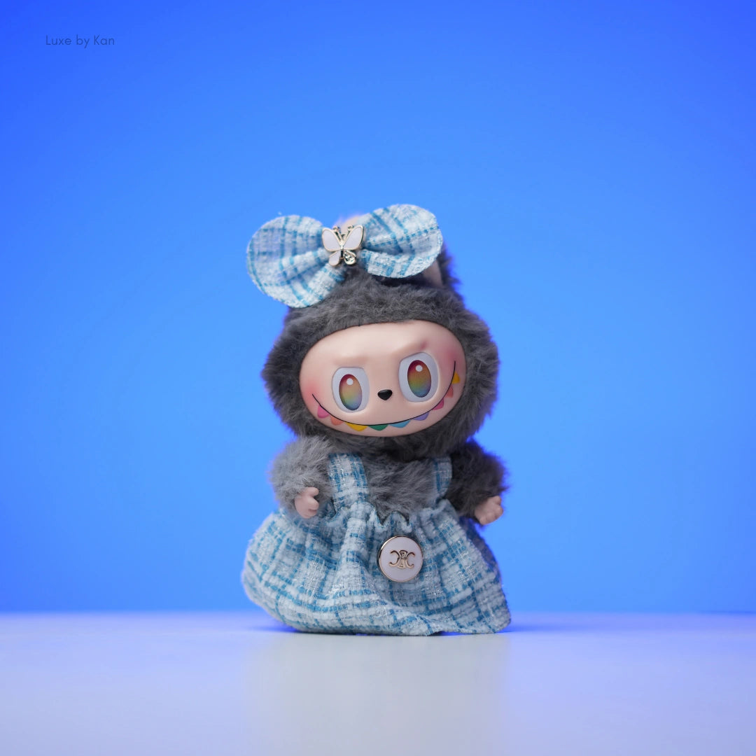 Labubu doll in a tweed dress outfit with a bow.