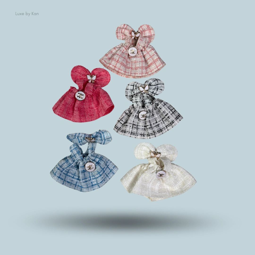 Five tweed labubu doll dresses with bows in pink, red, grey, blue, and white.