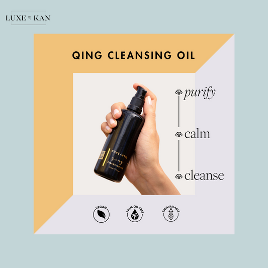 A hand holds a bottle of QING Cleansing Oil on a pastel background, promoting purification, calming, and cleansing benefits. Vegan and palm oil-free.