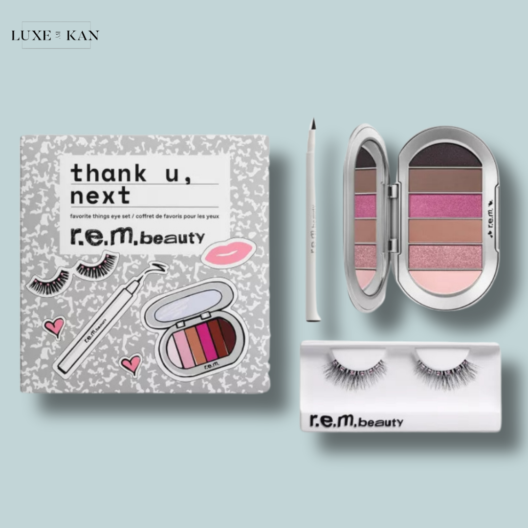A beauty set featuring an eye shadow palette, eyeliner, false lashes, and decorative packaging labeled "thank u, next" by r.e.m. beauty.