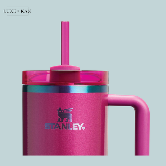 Close up of a Valentine’s Day Stanley Quencher 2.0 Flowstate tumbler in pink with a straw and iridescent band.