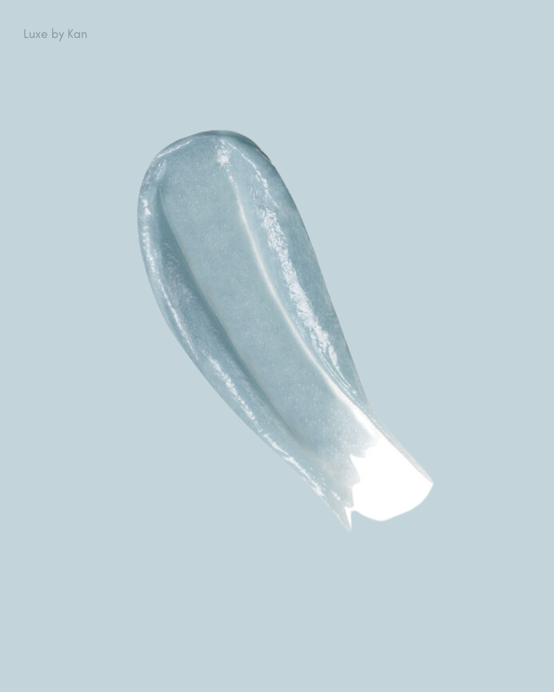 A glossy, light blue gel texture swatch against a soft gray background, suggesting a skincare product.