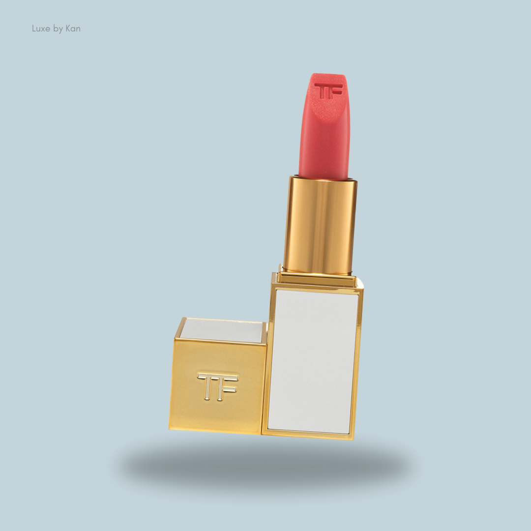 A stylish Tom Ford Lip Color Sheer in shade 04 Paradiso, featuring a vibrant coral-red bullet and the initials "TF" on the casing.