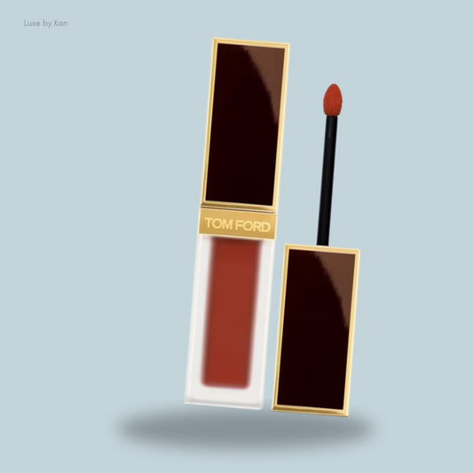 A Tom Ford liquid lipstick with a sleek gold and dark brown packaging and an applicator wand.