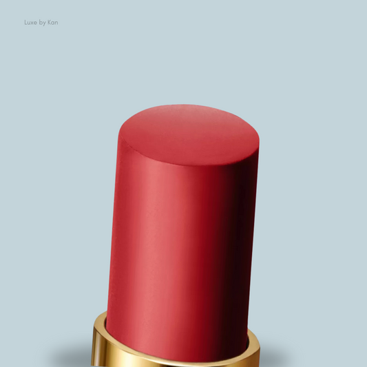 A close-up of a sleek Tom Ford matte red lipstick bullet with a gold base, featuring a smooth, rounded top.