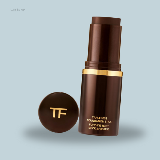 A brown Traceless Foundation Stick with a gold accent, next to its round cap.