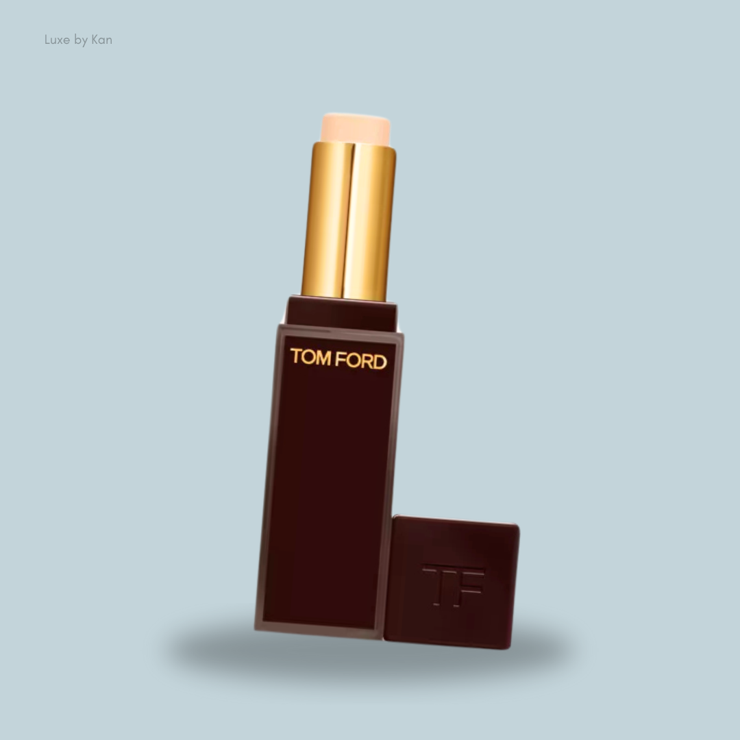 A Tom Ford Traceless Soft Matte Concealer in a sleek dark brown tube with gold accents, showcasing a light beige tip.