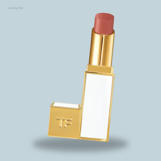 A sleek gold lipstick tube with a creamy nude shade, featuring a minimalist design and a white panel.