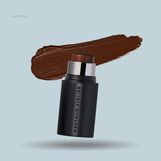 Westman Atelier's Petite Face Trace Contour Stick with a smear of brown pigment on light blue.
