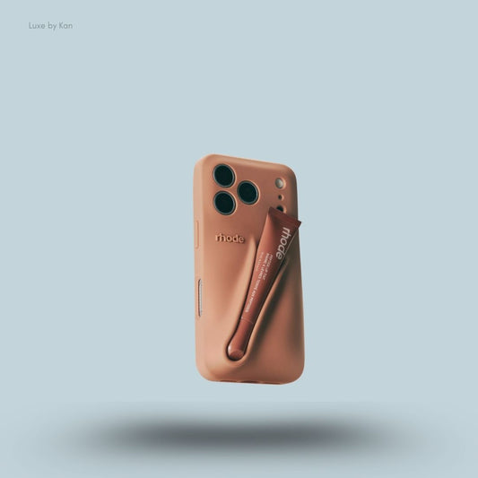 Rhode phone case in colada against blue background; the word "rhode" embossed on the back, with loop for lip balm.