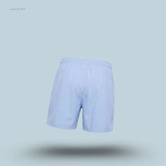 Gymshark Washed Pastels Shorts in purple displayed on a blue background with a relaxed athletic shorts design back view