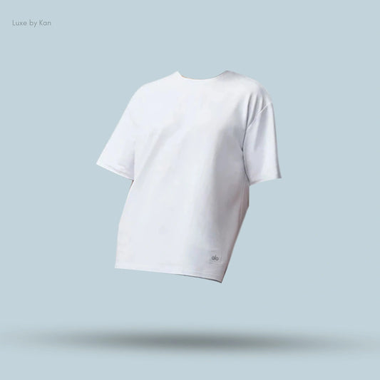 Alo Double Take Short Sleeve in White, flat lay on light blue background