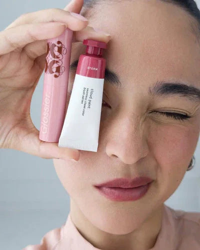 A women Holding Glossier makeup products