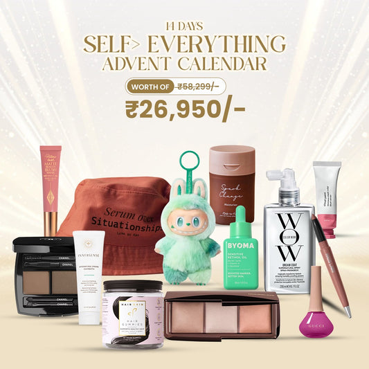 Self Everything Advent Calendar products featuring high-end makeup, skincare, and hair care items on a gold background.