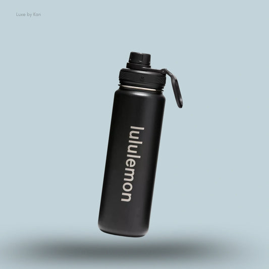 Lululemon Back to Life Sport Bottle 24oz in black, flat lay on light blue background